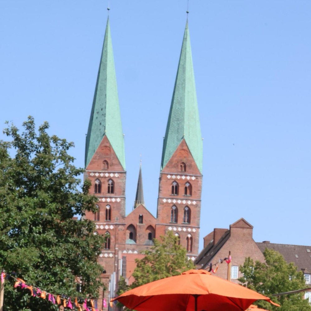 Blick über die Schirme und Fähnchen des Bürgerfests auf die Zwillingstürme der Marienkirche in der Altstadt.